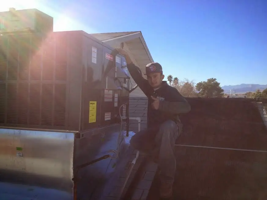HVAC technician performing AC Tune-Up on a rooftop unit in Seminole